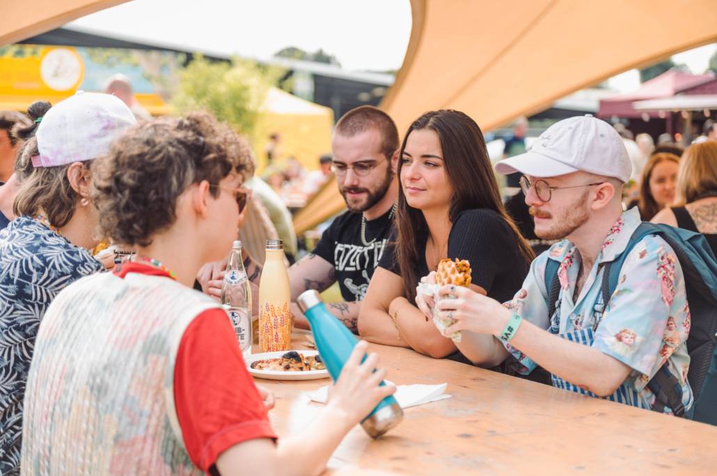 Mensen die samen eten aan tafel op Vegan Summer Fest