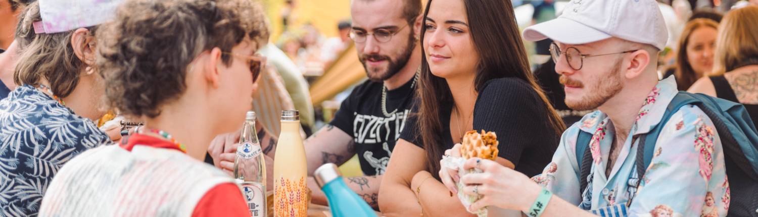 Mensen die samen eten aan tafel op Vegan Summer Fest